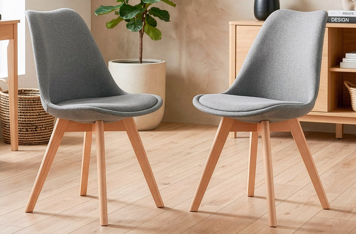 Silla de comedor tapizada Bistro gris de Kifoni junto a una mesa en un ambiente real