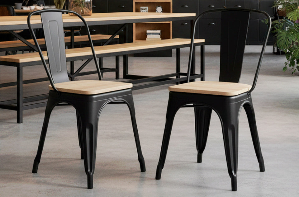 Deux chaises de salle à manger Tolix noir assise chêne dans une salle à manger avec tables et bancs