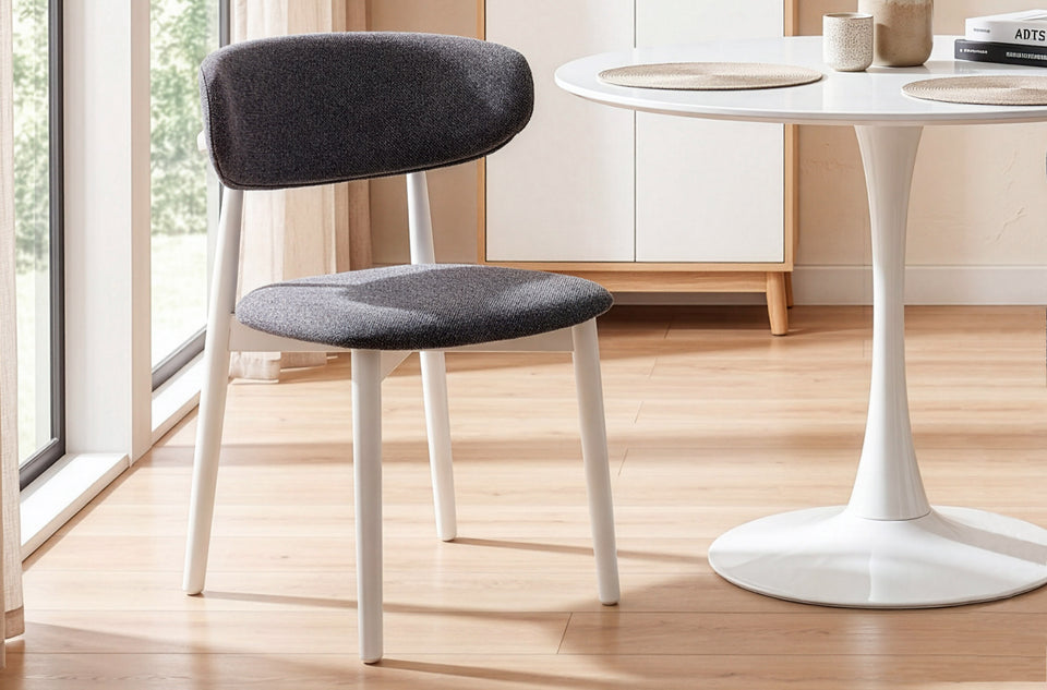 Silla de comedor Vera en la variante Gris / Blanco, junto a una mesa redonda de pie central