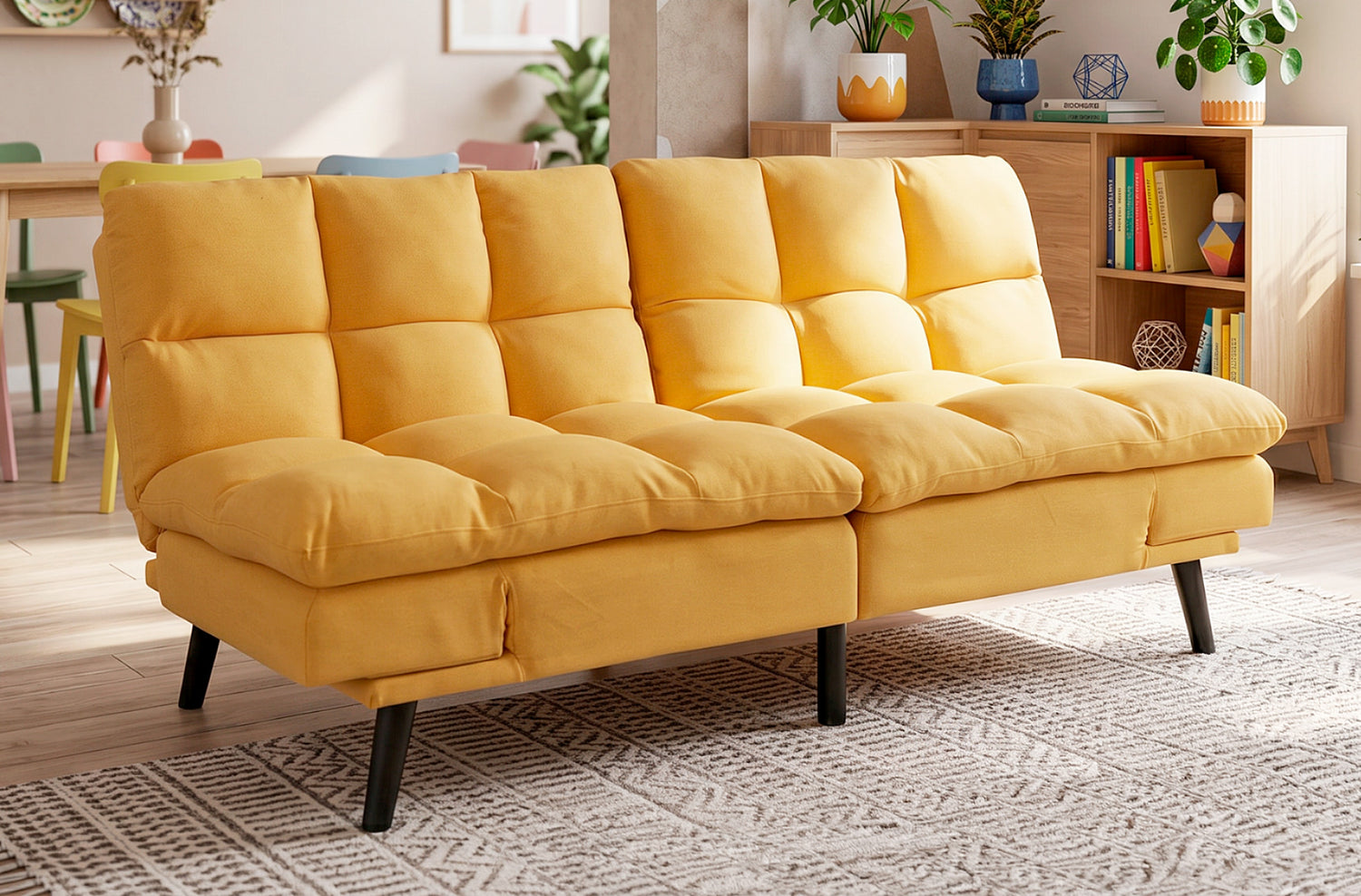 Sofá cama Cushion mostaza en un salón, junto a una estantería y una planta