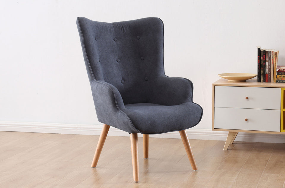 Fauteuil Voss gris dans un salon, près d'un meuble bas, pieds en bois apparents