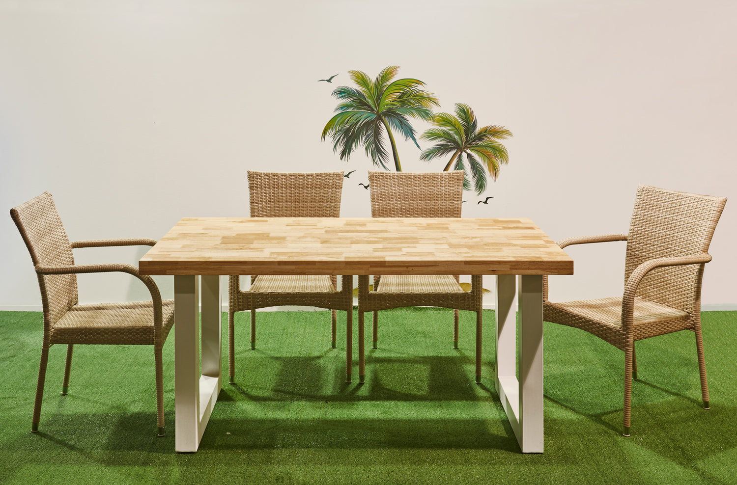 Mesa de exterior Loft Outdoor en una terraza con césped, rodeada de cuatro sillas