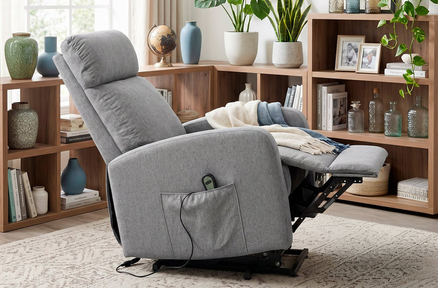 El sillón gris reclinado, con el reposapiés extendido, junto a una estantería.